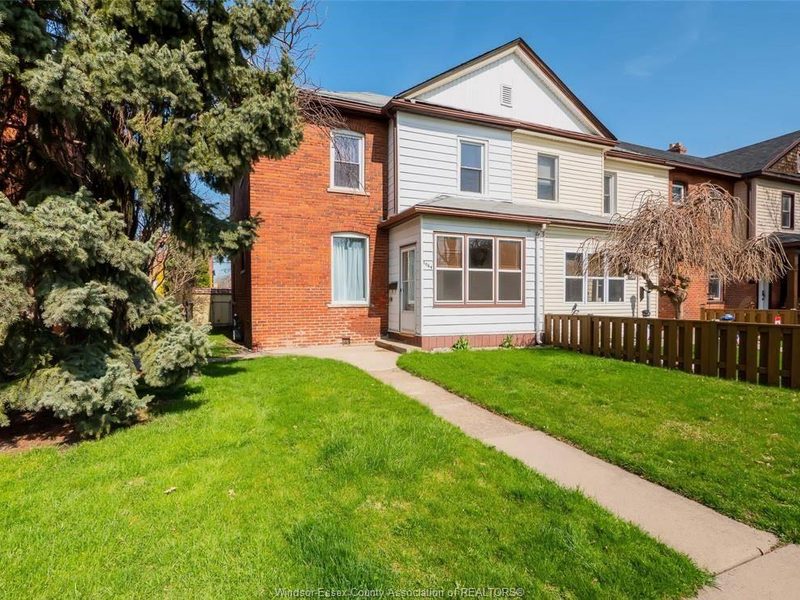 Brick semi-detached home at 1064 Monmouth Road with a green lawn