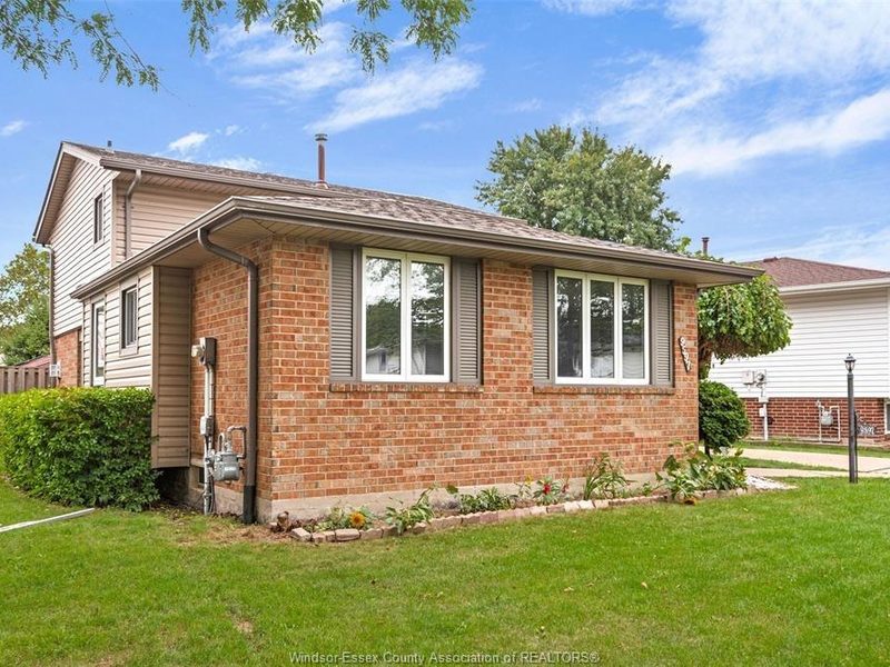 Brick back-split home at 9597 Avery Lane with a front lawn